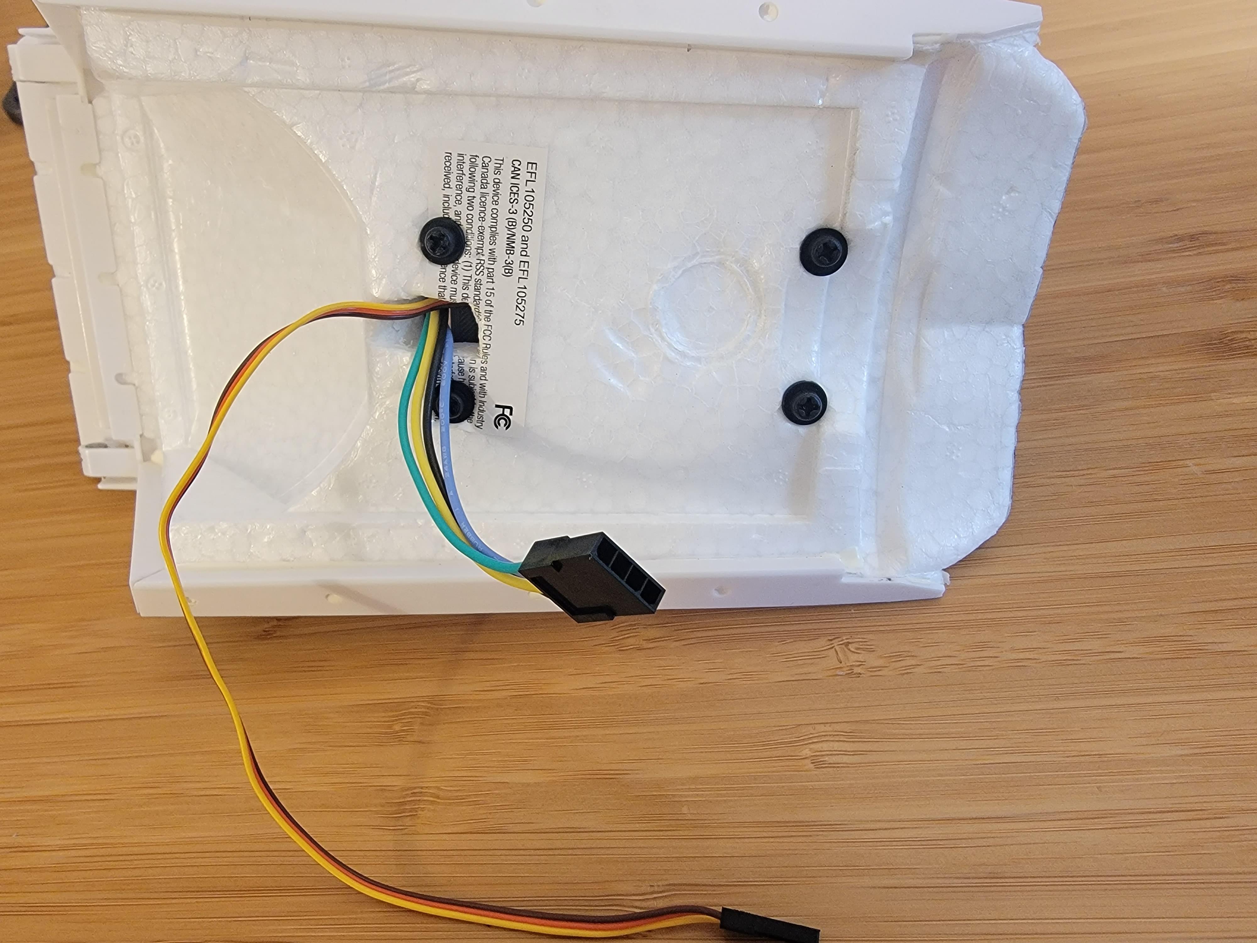 Underside of hatch showing the FPV pod attachment screws and wires pulled through
